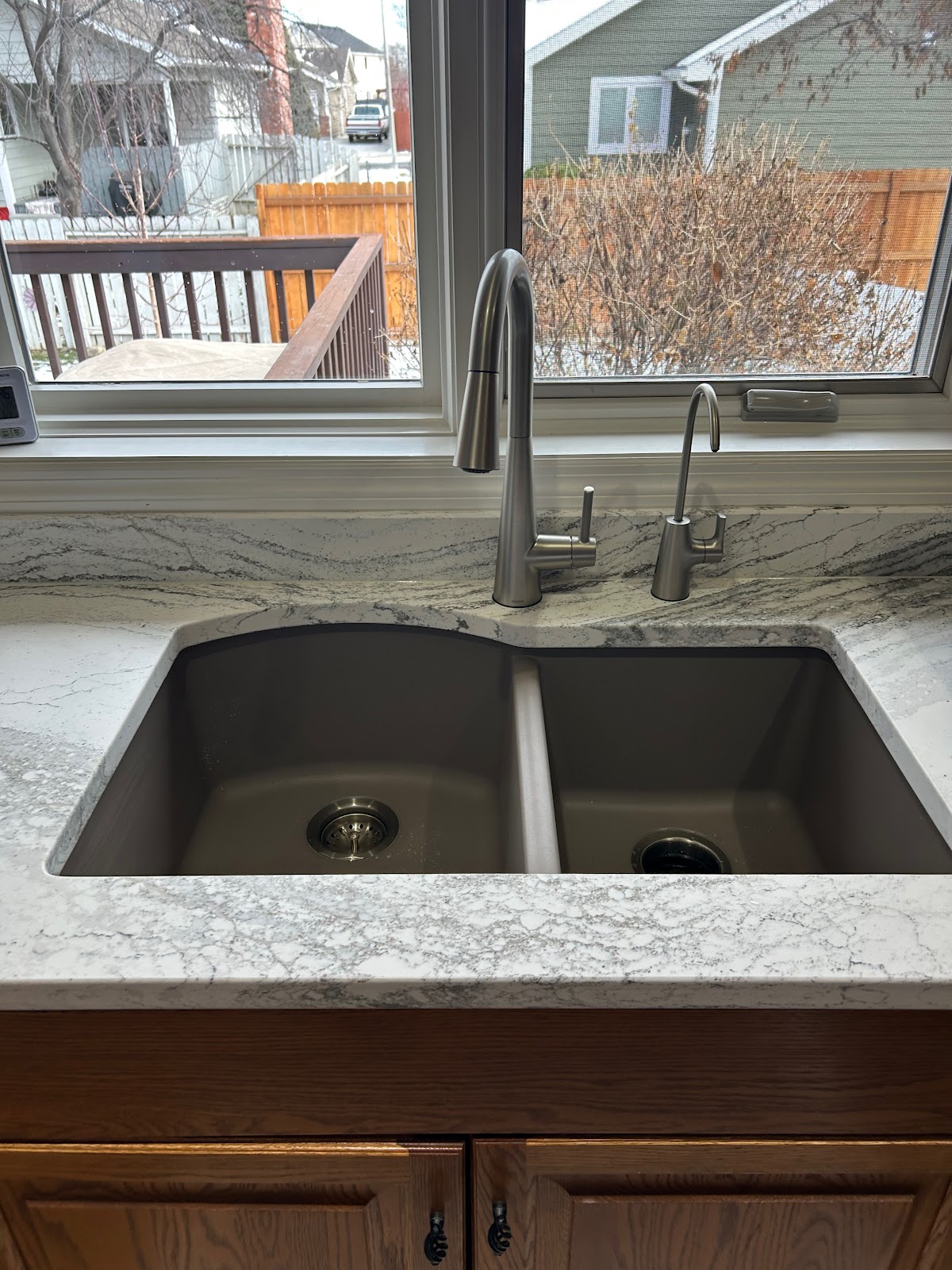 Double-bowl kitchen sink under a window